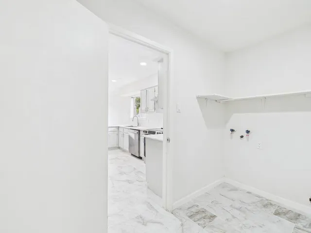 an empty room with a bathroom and a window