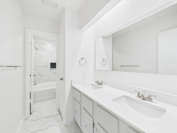 a bathroom with a sink a tub and a mirror