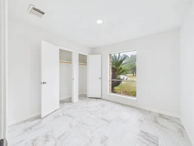 a front view of house with yard and trees all around