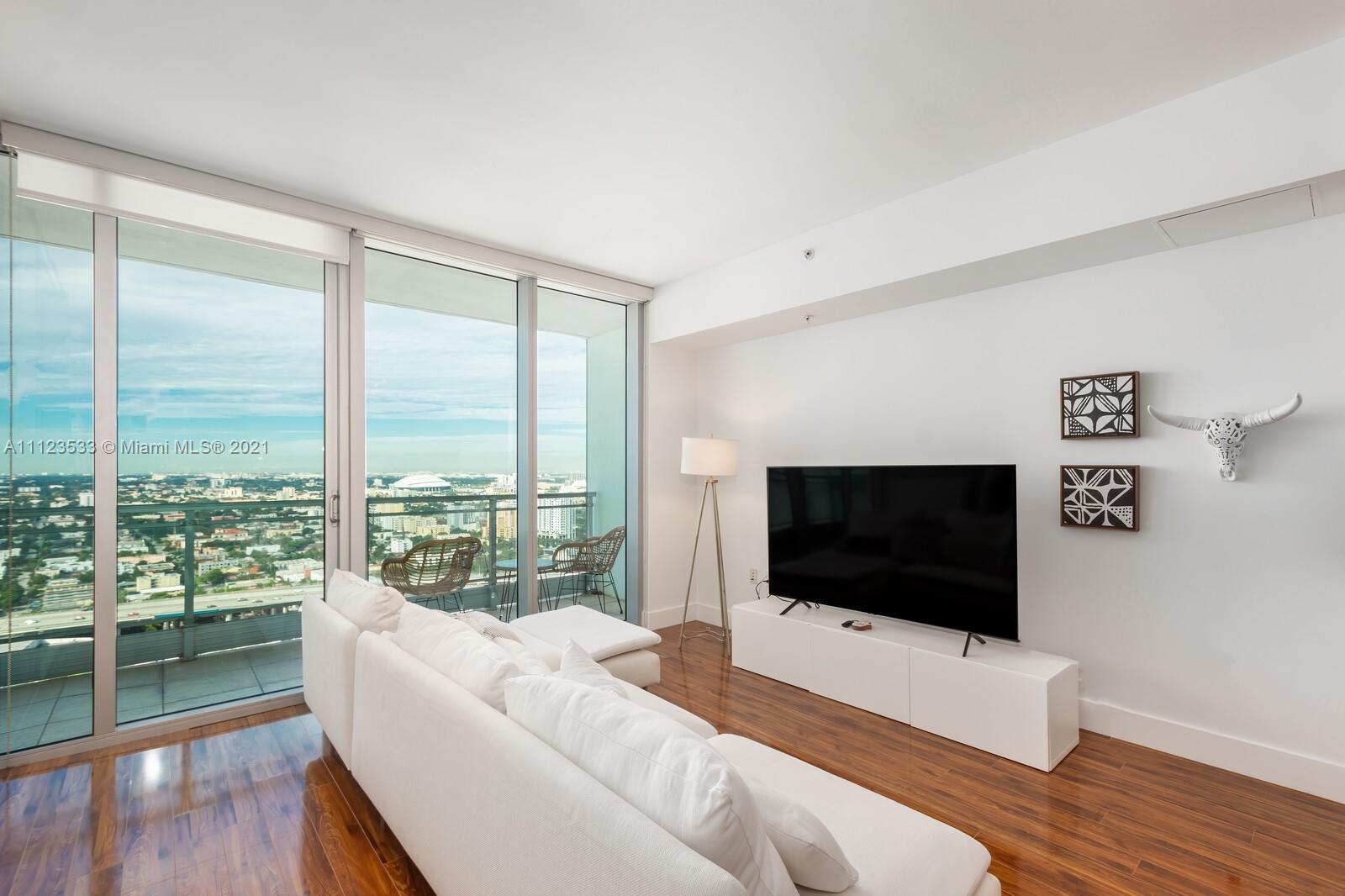92 Southwest 3rd Street, Unit 3507 Miami, FL 33130 - Photo 2 of 12 a living room with a large window and a flat screen tv
