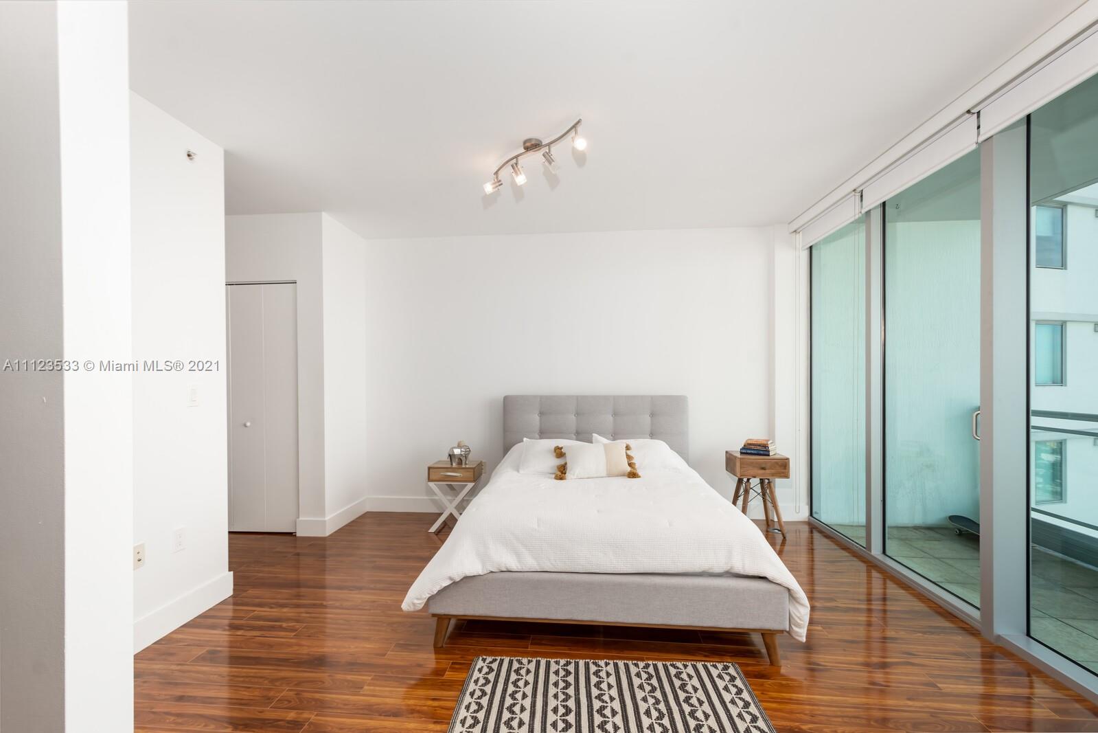 92 Southwest 3rd Street, Unit 3507 Miami, FL 33130 - Photo 5 of 12 a bedroom with a bed and wooden floor