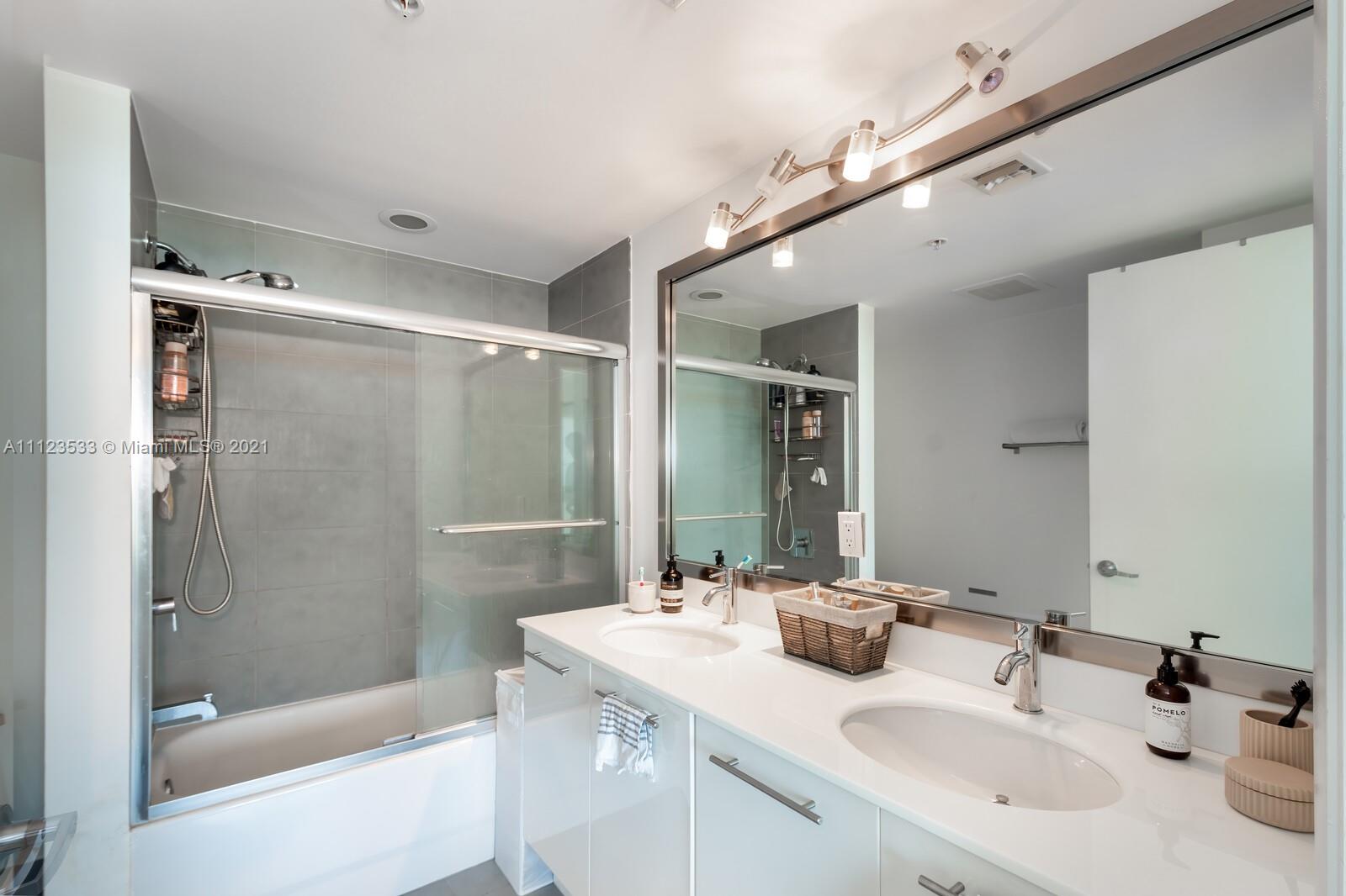 92 Southwest 3rd Street, Unit 3507 Miami, FL 33130 - Photo 9 of 12 a bathroom with a bathtub shower sink vanity and mirror