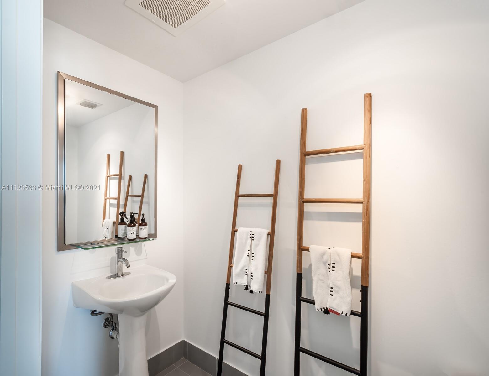 92 Southwest 3rd Street, Unit 3507 Miami, FL 33130 - Photo 10 of 12 a bathroom with a sink and a mirror
