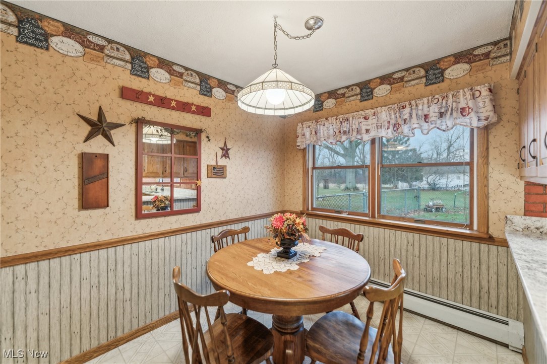 6326 Murray Ridge Road Elyria, OH 44035 - Photo 14 of 49 Dining room featuring baseboard heating and wood walls