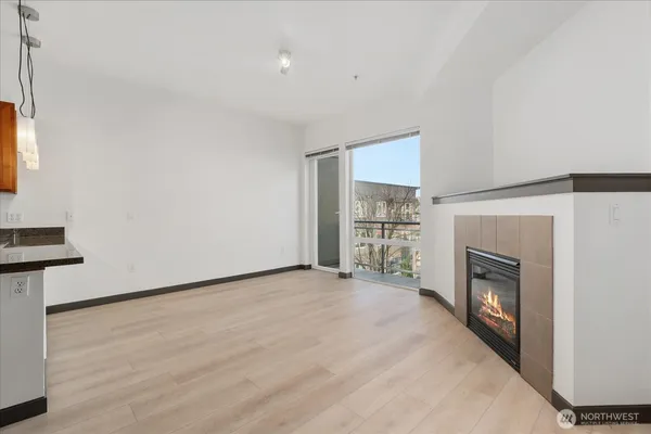 a view of an empty room with a fireplace and a window