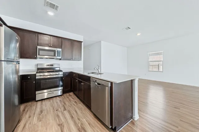 a kitchen with stainless steel appliances granite countertop a stove a sink and a refrigerator