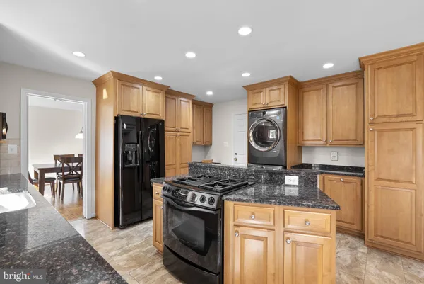 a kitchen with stainless steel appliances granite countertop a stove a refrigerator and a cabinets
