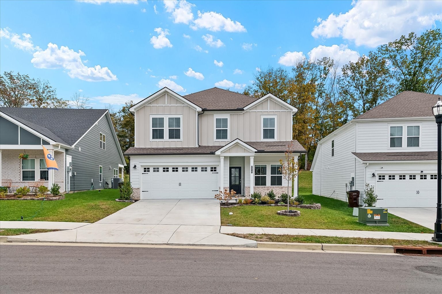 a front view of a house with a garden and trees