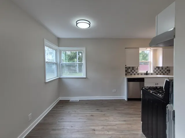 a kitchen with granite countertop a stove a sink and a refrigerator
