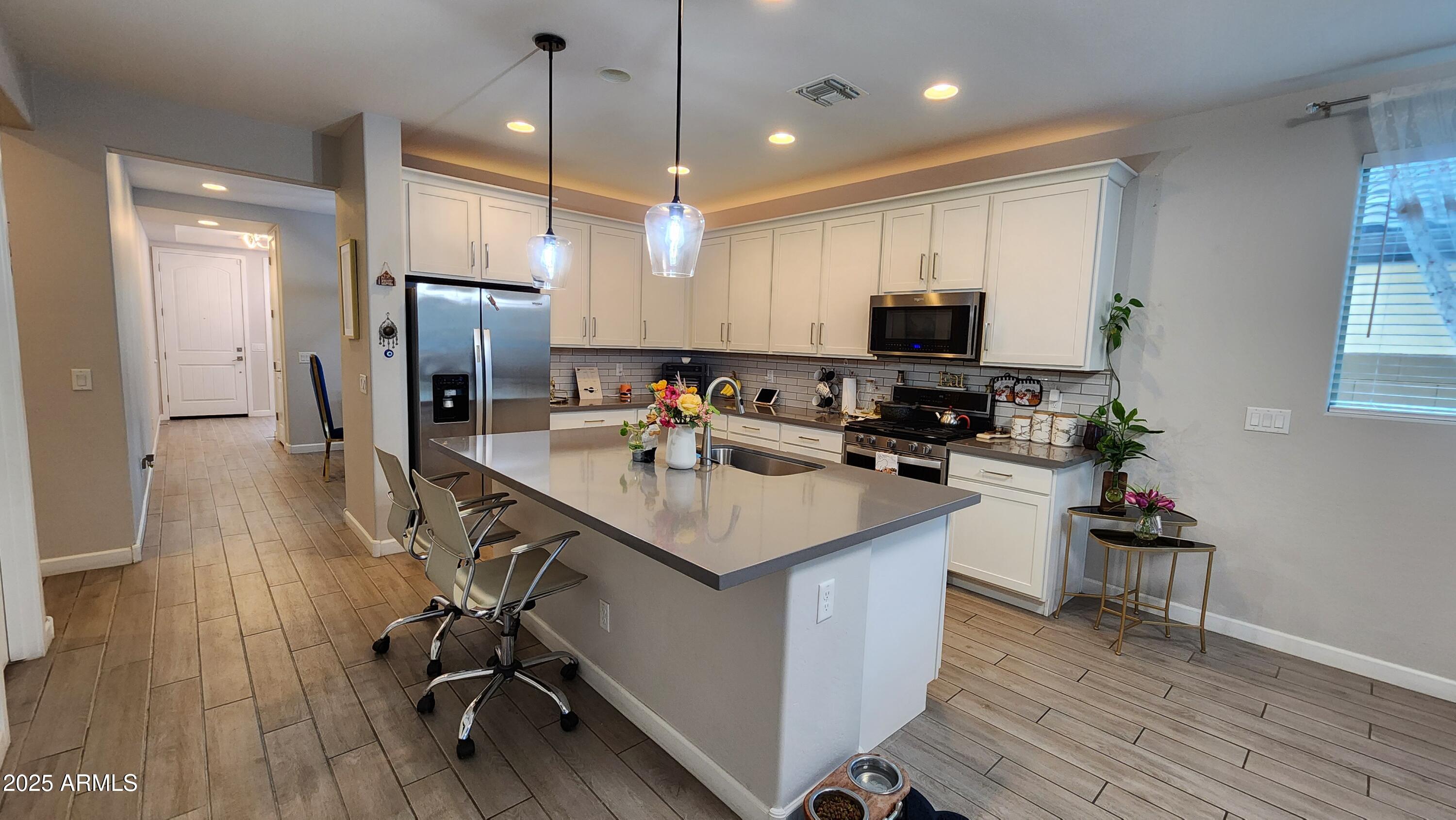 14400 West Bloomfield Road Surprise, AZ 85379 - Photo 8 of 38 a kitchen with a sink a counter top space appliances and cabinets