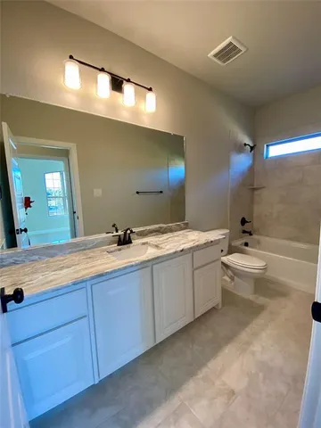 a bathroom with a double vanity sink toilet mirror and bathtub