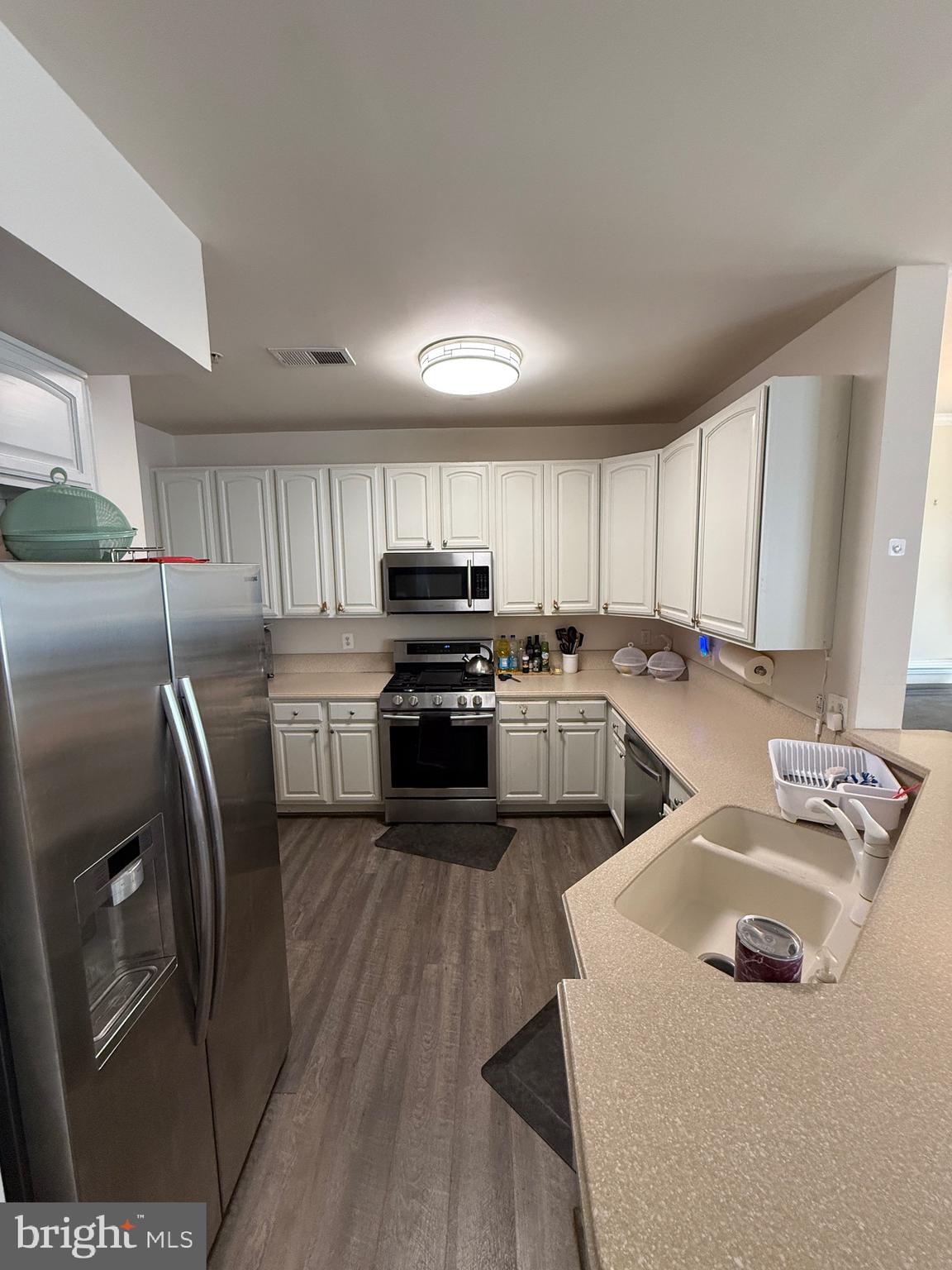 4617 Hummingbird Lane, Unit 110 Fairfax, VA 22033 - Photo 11 of 45 a kitchen with refrigerator a sink and cabinets