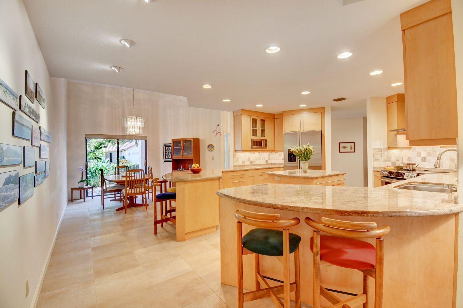 23383 Water Circle Boca Raton, FL 33486 - Photo 25 of 35 a kitchen with stainless steel appliances granite countertop dining table chairs and a refrigerator