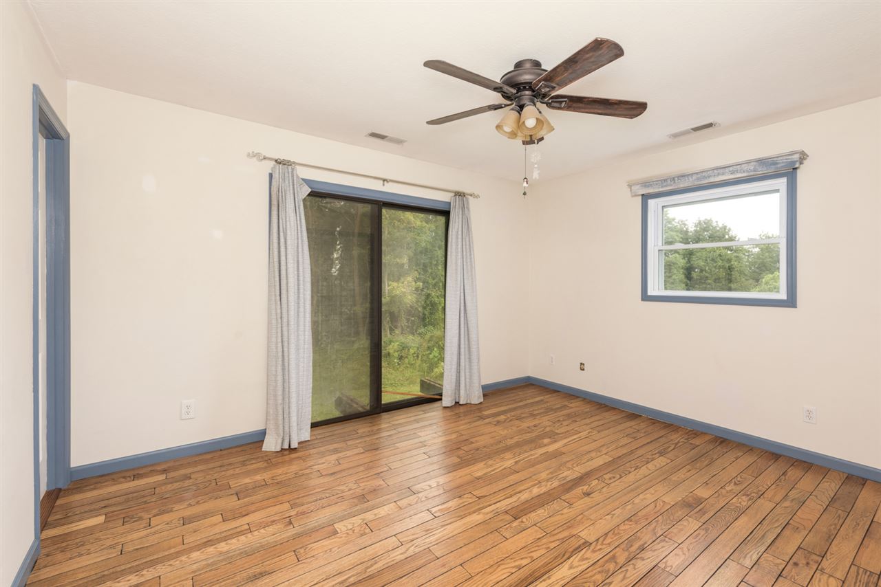1959 Shutterlee Mill Road Staunton, VA 24401 - Photo 6 of 50 an empty room with wooden floor ceiling fan and windows