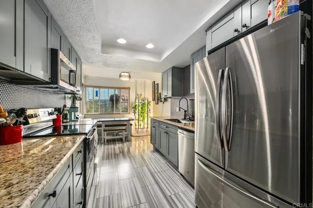 a kitchen with stainless steel appliances granite countertop a refrigerator stove and oven