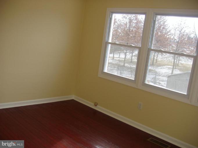 2777 Yarnall Road Halethorpe, MD 21227 - Photo 13 of 23 an empty room with wooden floor and windows