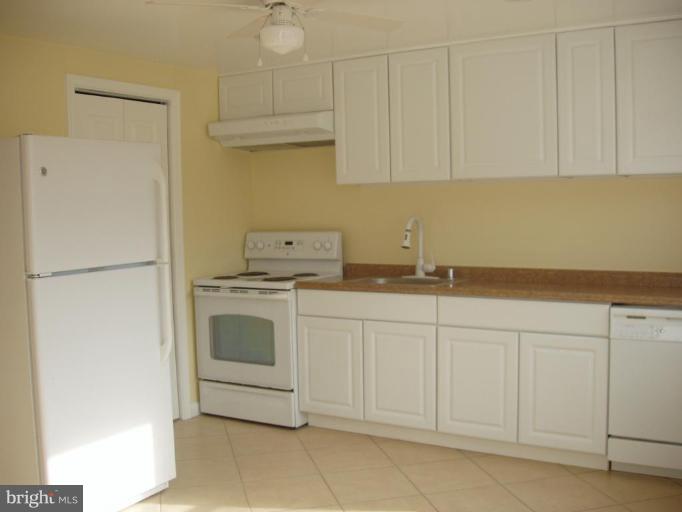 2777 Yarnall Road Halethorpe, MD 21227 - Photo 6 of 23 a kitchen with white cabinets and white appliances