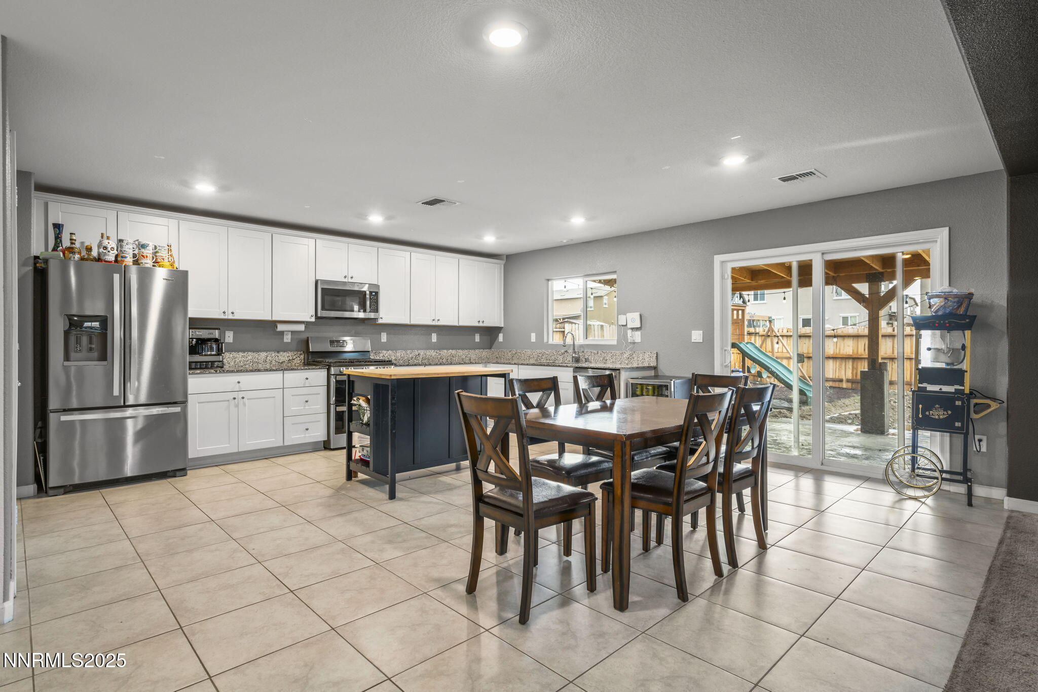 8961 Buffalo Grove Drive Reno, NV 89506 - Photo 4 of 23 a kitchen with granite countertop a table chairs microwave and refrigerator