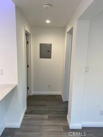 an empty room with wooden floor and entrance