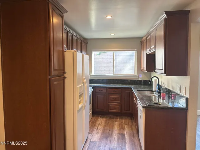 a kitchen with granite countertop a refrigerator and a sink