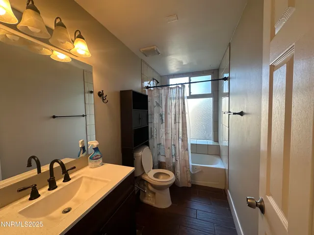 a bathroom with a double vanity sink toilet mirror and shower