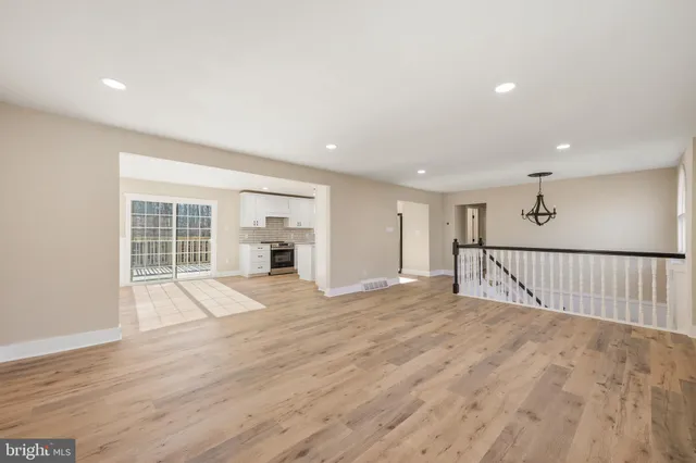 a view of a hallway with wooden floor and stairs