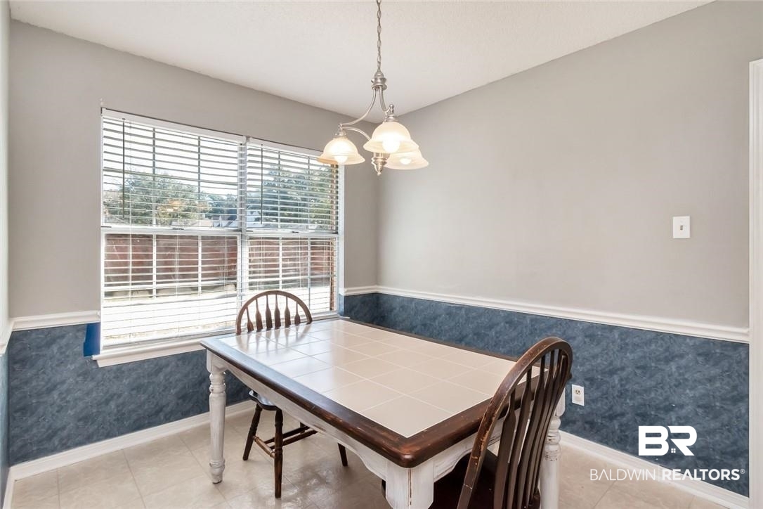 6601 Conde Court Mobile, AL 36695 - Photo 13 of 30 Dining area with light tile patterned floors and an inviting chandelier
