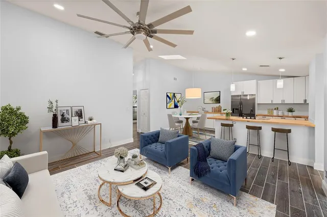 a living room with furniture kitchen view and a potted plant