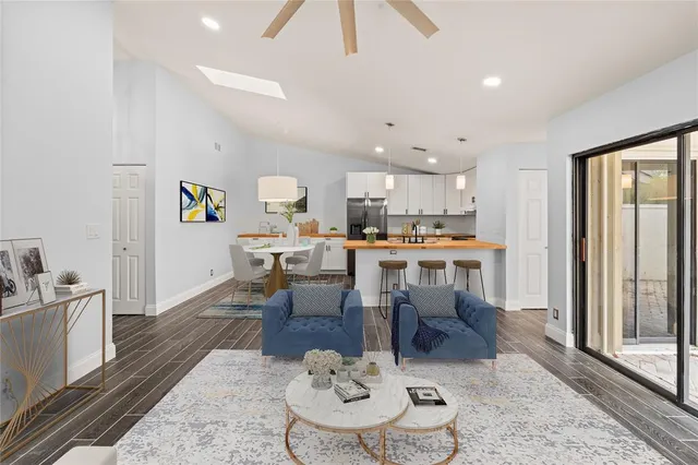 a living room with stainless steel appliances kitchen island granite countertop furniture and a rug
