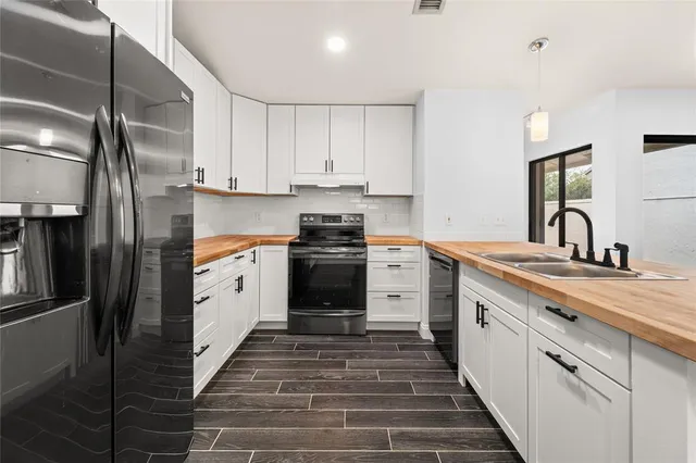 a kitchen with white cabinets and stainless steel appliances