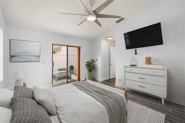 a bedroom with a bed tv and a window