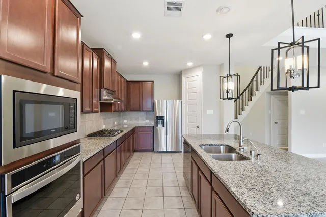 a kitchen with stainless steel appliances granite countertop a sink and stove