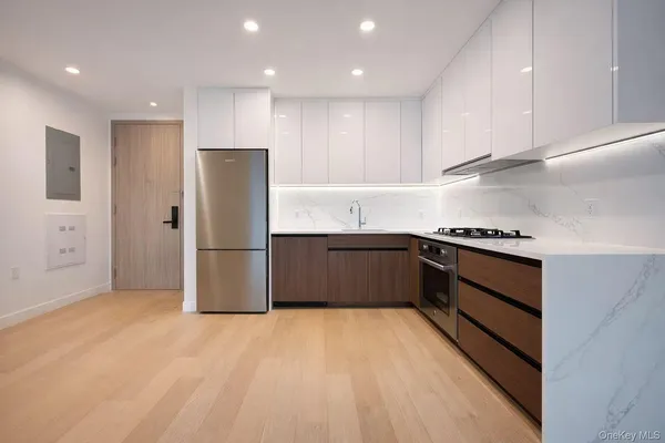 a kitchen with stainless steel appliances a refrigerator and a stove top oven