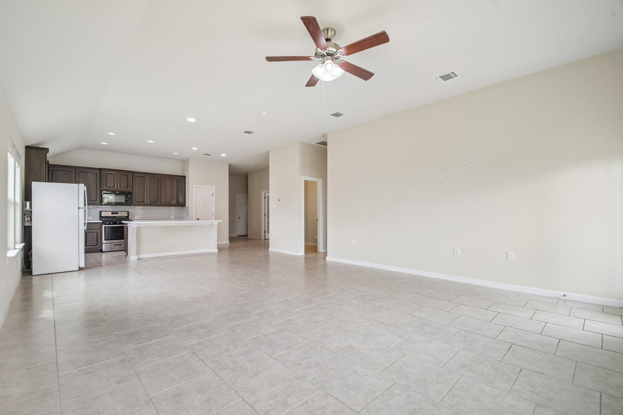 Tiled flooring and high ceilings define this open interior space leading to the kitchen area.