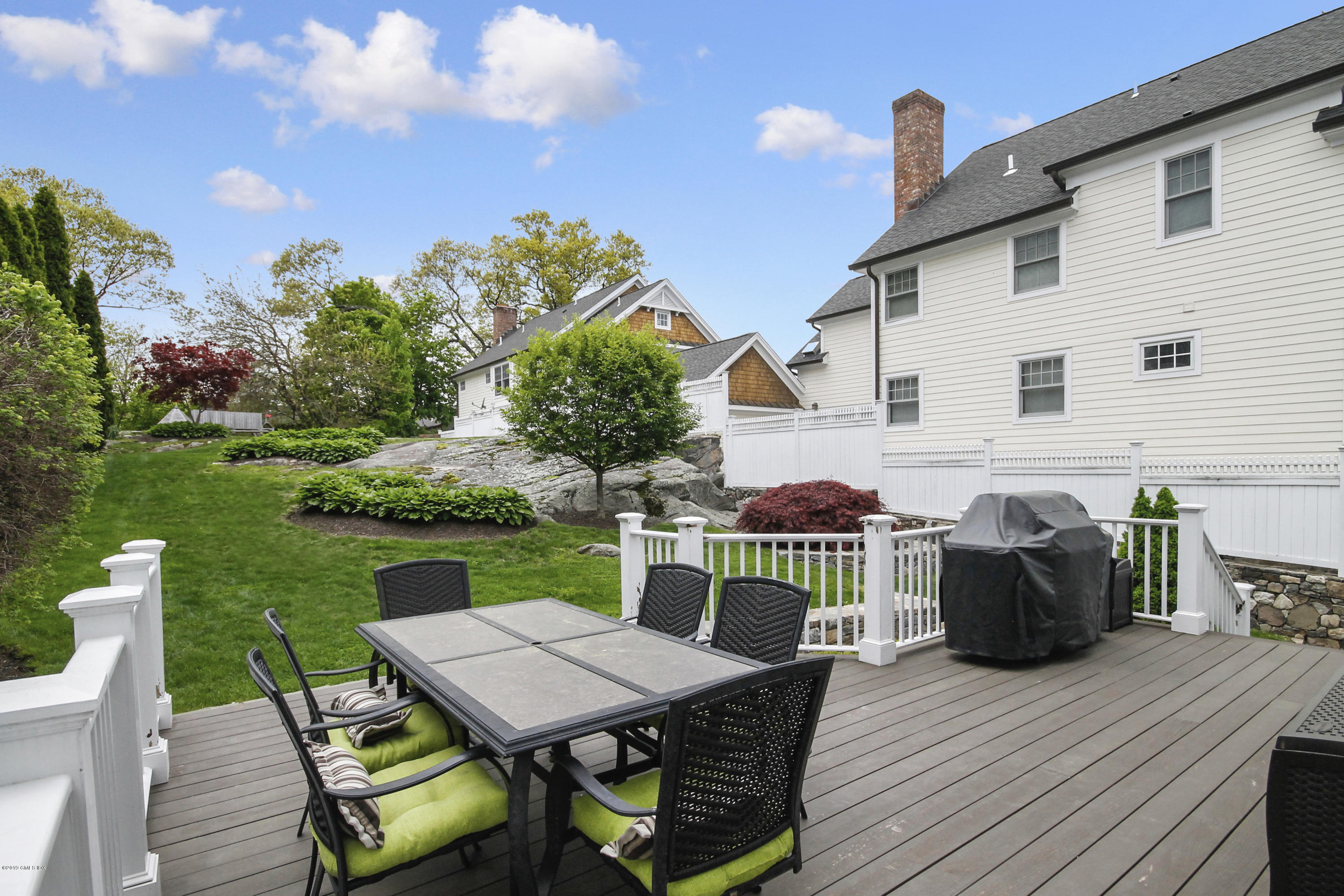 46 Orchard Place Greenwich, CT 06830 - Photo 28 of 34 a view of a patio with table and chairs with wooden floor and fence