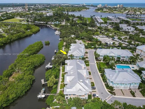 an aerial view of residential houses with outdoor space and lake view