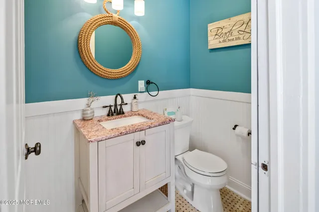 a bathroom with a granite countertop sink mirror vanity and toilet