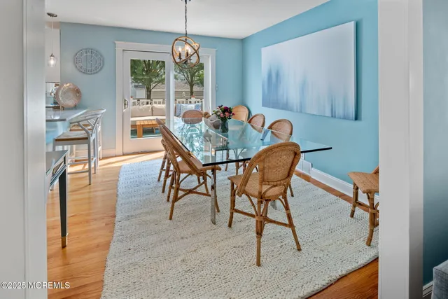 a work place with stainless steel appliances kitchen island granite countertop furniture and a wooden floor