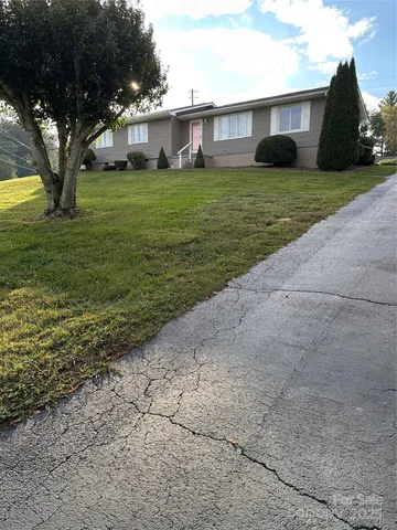 a front view of a house with a garden and trees