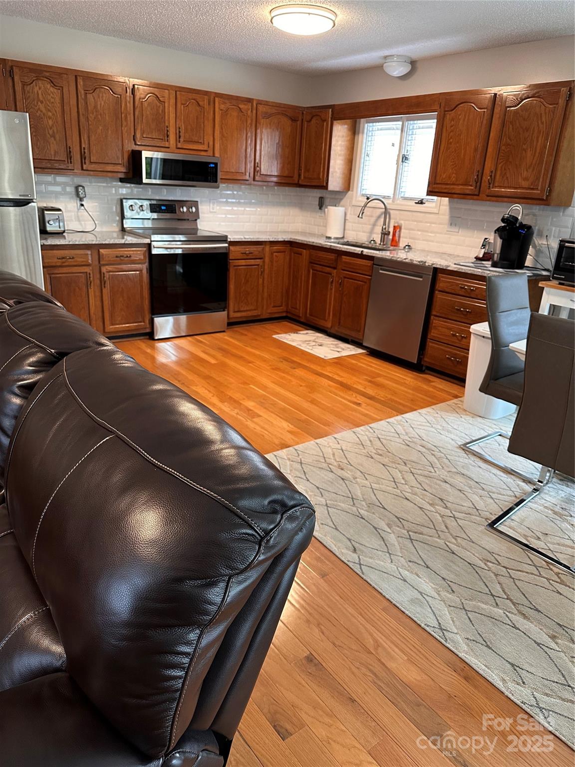 450 Case Cove Road, Unit 85 Candler, NC 28715 - Photo 5 of 14 a kitchen with stainless steel appliances kitchen island granite countertop a stove a sink and a microwave