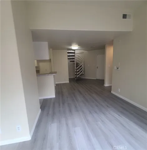 a view of empty room with wooden floor and fireplace