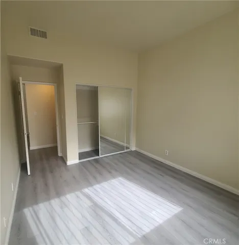 an empty room with wooden floor and closet