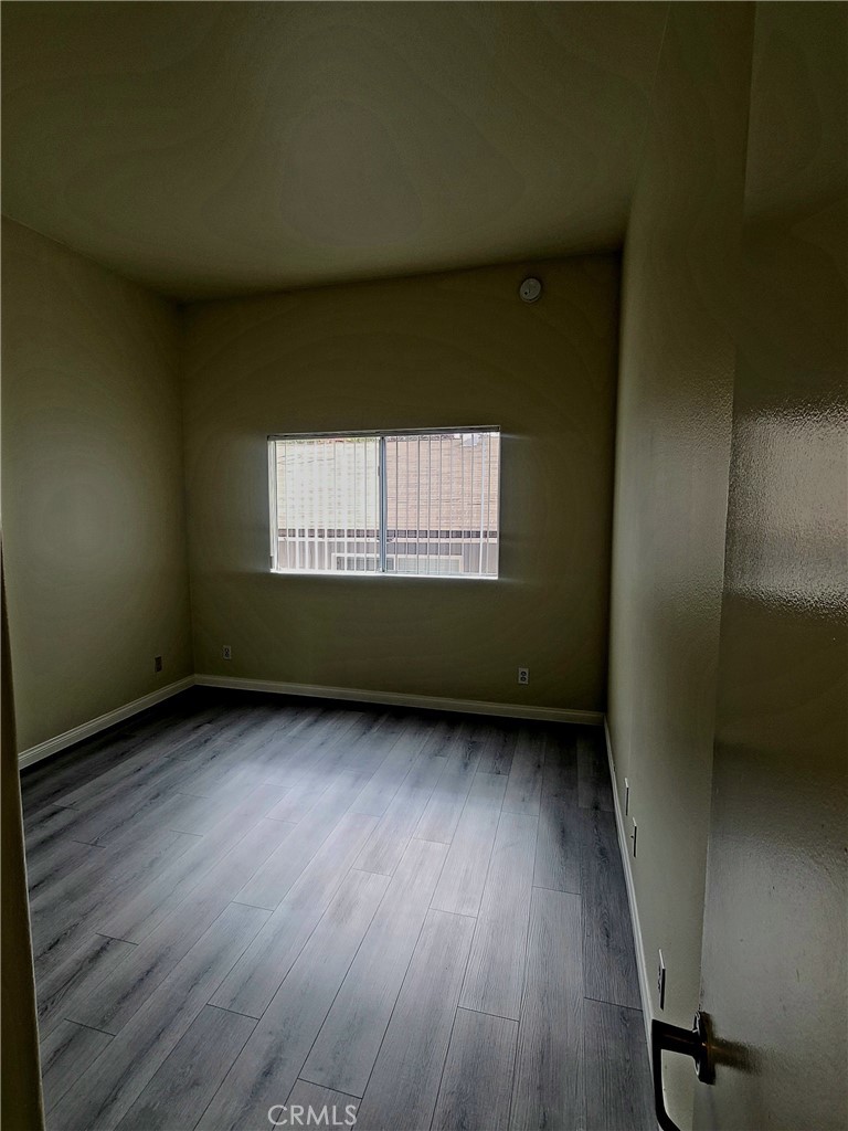5060 Kester Avenue, Unit 208 Sherman Oaks, CA 91403 - Photo 6 of 31 a view of an empty room with a window and wooden floor