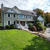 a front view of a house with a yard and potted plants