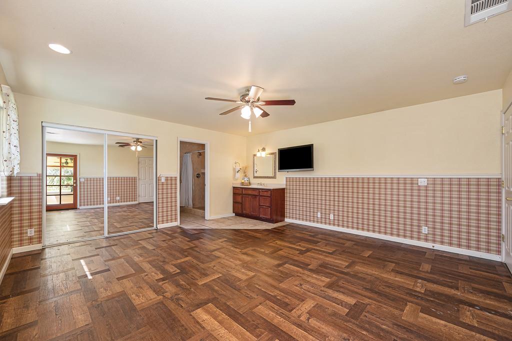 6181 Lambert Lane El Dorado, CA 95623 - Photo 42 of 68 unfurnished bedroom with a wainscoted wall, ensuite bathroom, a closet, parquet flooring, and a ceiling fan