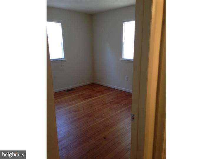 95 Linden Avenue, Unit B Pitman, NJ 08071 - Photo 3 of 15 a view of an empty room with wooden floor and a window