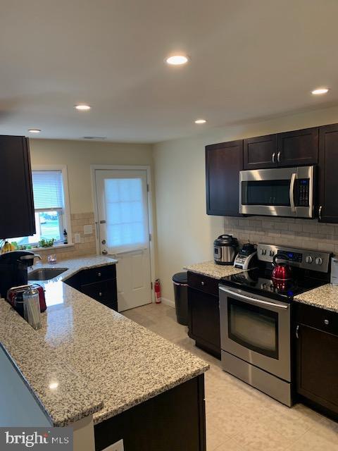 95 Linden Avenue, Unit B Pitman, NJ 08071 - Photo 7 of 15 a kitchen with stainless steel appliances granite countertop a stove a sink and a microwave