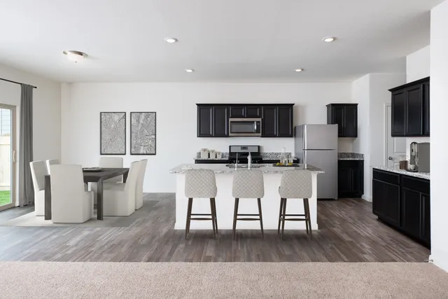 a living room with stainless steel appliances furniture and a flat screen tv