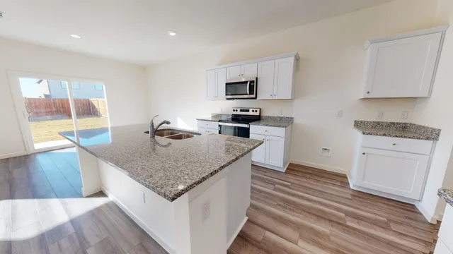 a kitchen with stainless steel appliances granite countertop a sink stove and refrigerator