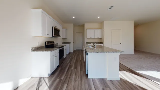 a kitchen with stainless steel appliances a microwave a stove a sink and a refrigerator